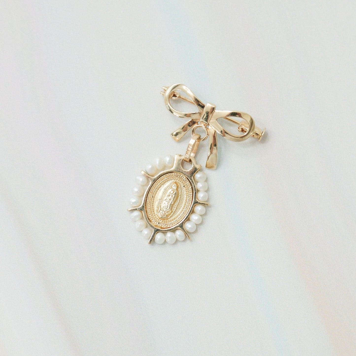 Medalla de perlitas con broche de moñito