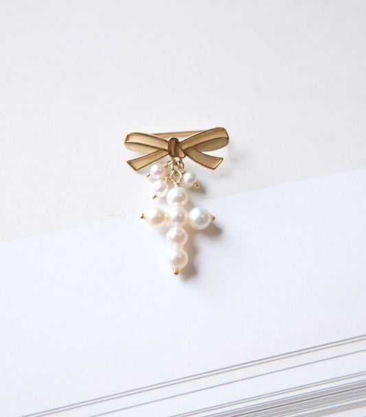 Cruz de perlas con broche de moño en oro 14k